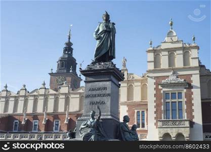 Monument of Adam Mickiewicz in Krakow by clock tower, Poland
