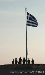 Monument of soldiers standing under the Greek flag in Athens, Greece