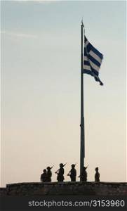 Monument of soldiers standing under the Greek flag in Athens, Greece