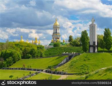 Monument to victims of Holodomor and Domes of Kiev-Pechersk Lavra in Kiev on green hills of Pechersk. &#xA;Park of Fame in Kyiv. Ukraine