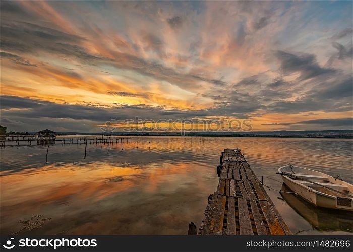 mood and tranquility at a lake coast with a boat at a wooden pier