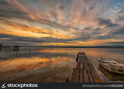 mood and tranquility at a lake coast with a boat at a wooden pier