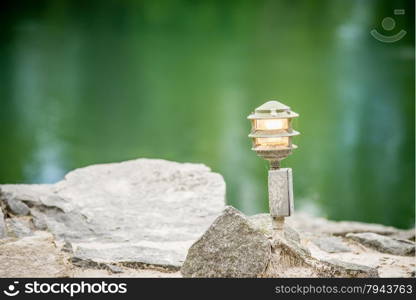 mood lighting light fixture on rocks by the water