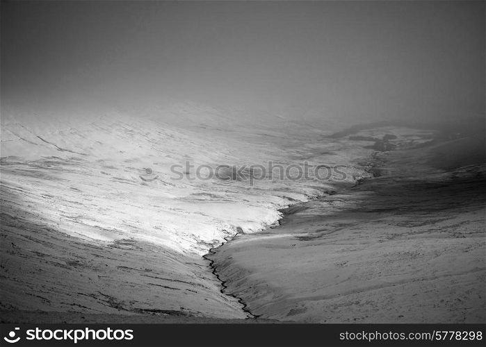 Moody dramatic low cloud Winter landscape in mountains in black and white