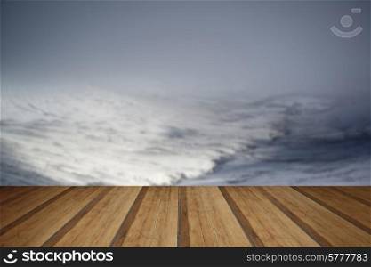 Moody dramatic low cloud Winter landscape in mountains with snow on ground with wooden planks floor
