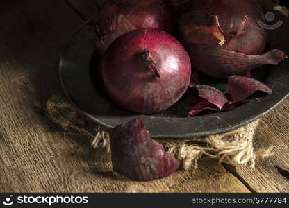 Moody natural light vintage style image of fresh red onions