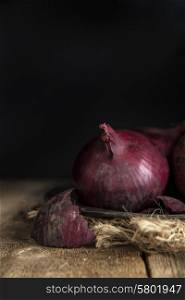 Moody natural light vintage style image of fresh red onions