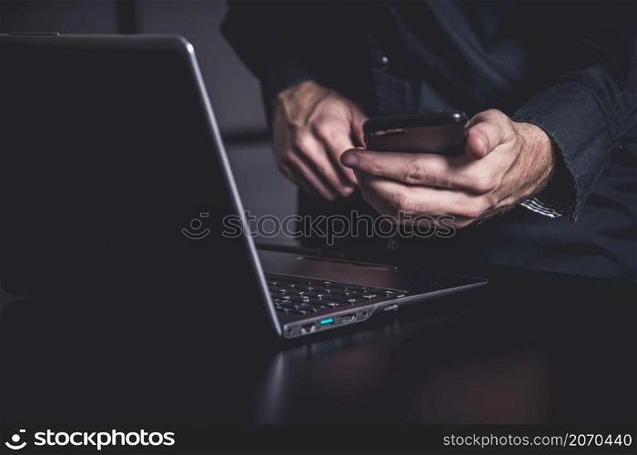 Moody office with a businessman with samrtphone and notebook