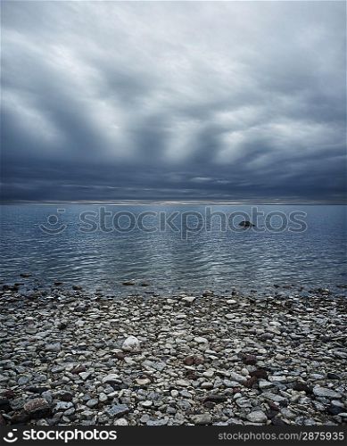 Moody sky over rocky beach