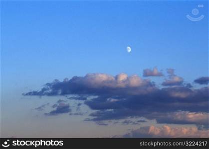 Moon And Clouds In A Clear Blue Sky At Dusk