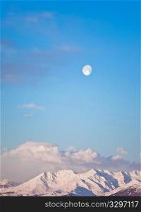 Moon and mountain landscape early in the morning, vertical frame