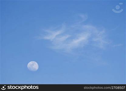 Moon and soft clouds in evening sky, peaceful day.