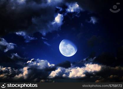 moon and stars in a cloudy night blue sky