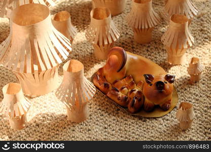 Moon cakes for mid autumn season in mother pig and piggy shape with group of many size lanterns from kraft paper on burlap background at bright sunshine morning