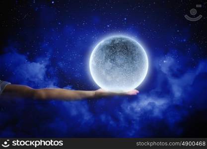 Moon in hand. Close up of human hand touching moon planet