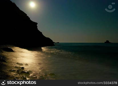 Moon night on the sea with waves and rocks.