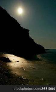 Moon night on the sea with waves and rocks.