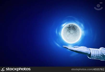 Moon on hand. Person hand with moon on palm on blue background