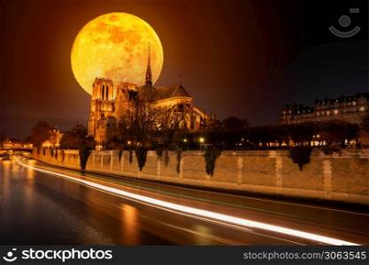 Moon over Notre Dame cathedral before it burned with ships trails on the water at night in Paris