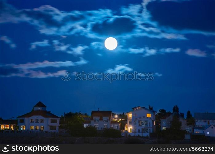 Moon over the river by the town with blue sky and clouds
