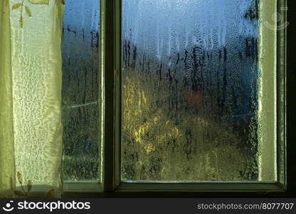 Moonlight through the window. Sweaty glass