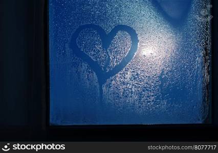 Moonlight through the window. Sweaty glass and heart shape