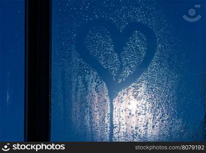 Moonlight through the window. Sweaty glass and heart shape