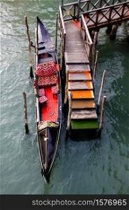 Moored Gondola in Venice canal walkway with Wood