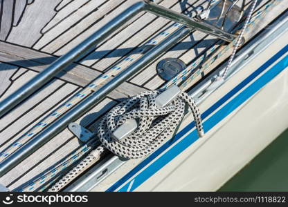 Mooring rope with a knotted end tied around a cleat on a yacht side