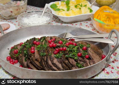 Moose steak in slices ready to serve at a table