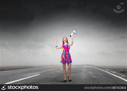More colors. Young girl in multicolored bright dress screaming in megaphone