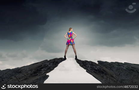 More colors. Young girl in multicolored bright dress standing above gap