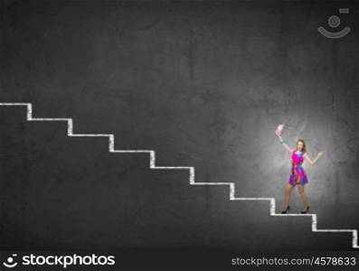 More colors. Young girl in multicolored bright dress walking on staircase