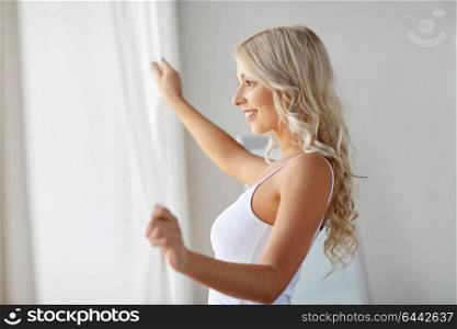 morning and people concept - beautiful young woman in white underwear at window. woman in underwear at window in morning