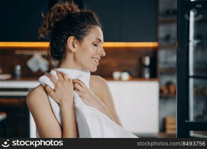 Morning beauty routine. European girl is wiping face with soft towel after washing. Happy young woman takes shower at home and doing skin care. Hygiene, dermatology and spa procedures.. Morning beauty routine. Happy european girl is wiping face with soft towel after washing.