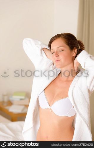 Morning bedroom - woman in bathrobe and bra waking up
