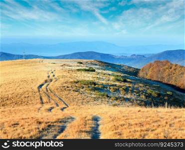 Morning Carpathian Mountains  Ukraine  autumn landscape with country road and wooden Cross on hill.