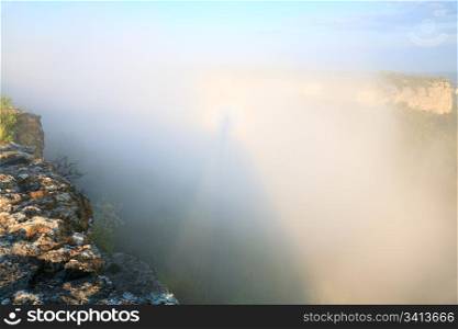 Morning cloudy view from top of Mangup Kale (historic fortress and ancient cave settlement in Crimea, Ukraine) and shadow on cloud with halo