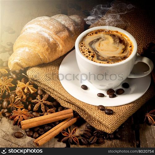 Morning coffee and croissant with spices on table