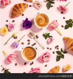 Morning coffee, croissants and a beautiful flowers pattern. Cozy breakfast on pink background. Flat lay composition for bloggers, magazines, web designers, social media and artists.