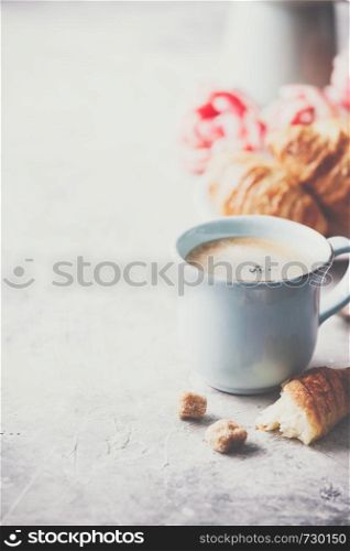 Morning coffee, croissants and spring tulips on light grey background, breakfast concept