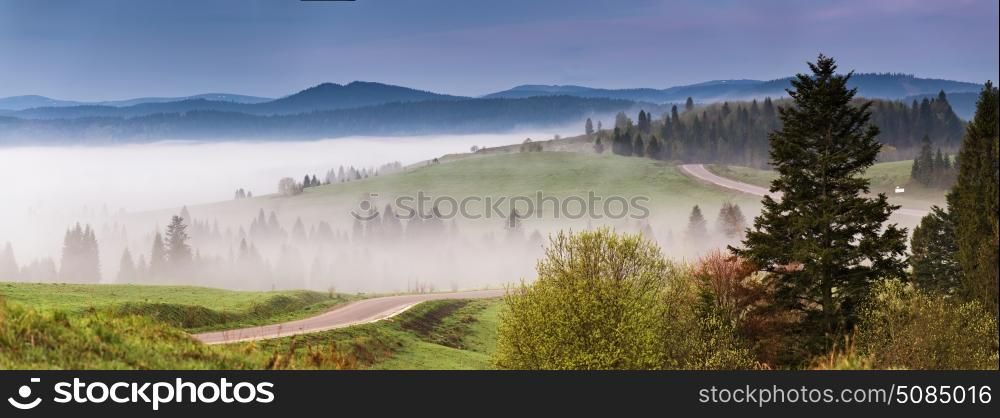 Morning empty asphalt road panorama. Beautiful Summer Mountain Road. Mountain range serpentine. Beautiful misty morning traveling background.