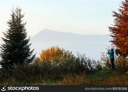 Morning fog on the slopes of the Carpathian Mountains (Ivano-Frankivsk oblast, Ukraine). View on Chornohora ridge and woman-photographer at the side.