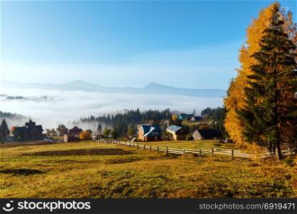 Morning fog on the slopes of the Carpathian Mountains (Yablunytsia village, Ivano-Frankivsk oblast, Ukraine). Autumn rural sunrise landscape.