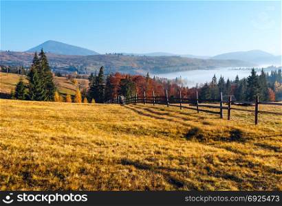 Morning fog on the slopes of the Carpathian Mountains (Yablunytsia village, Ivano-Frankivsk oblast, Ukraine). Autumn rural landscape.