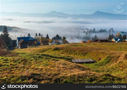 Morning fog on the slopes of the Carpathian Mountains  Yablunytsia village, Ivano-Frankivsk oblast, Ukraine . Autumn rural landscape.