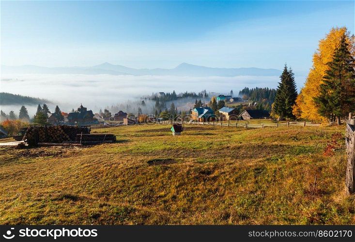 Morning fog on the slopes of the Carpathian Mountains  Yablunytsia village, Ivano-Frankivsk oblast, Ukraine . Autumn rural landscape.