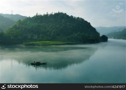 Morning fog rolls across the chilly river water, photo taken in hunan province of China
