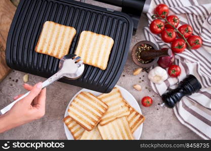 Morning homemade snack - Toast bread pan fried on black electric kitchen grill.. Morning homemade snack - Toast bread pan fried on black electric kitchen grill