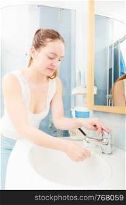 Morning hygiene. Woman cleaning washing her face with clean water in bathroom